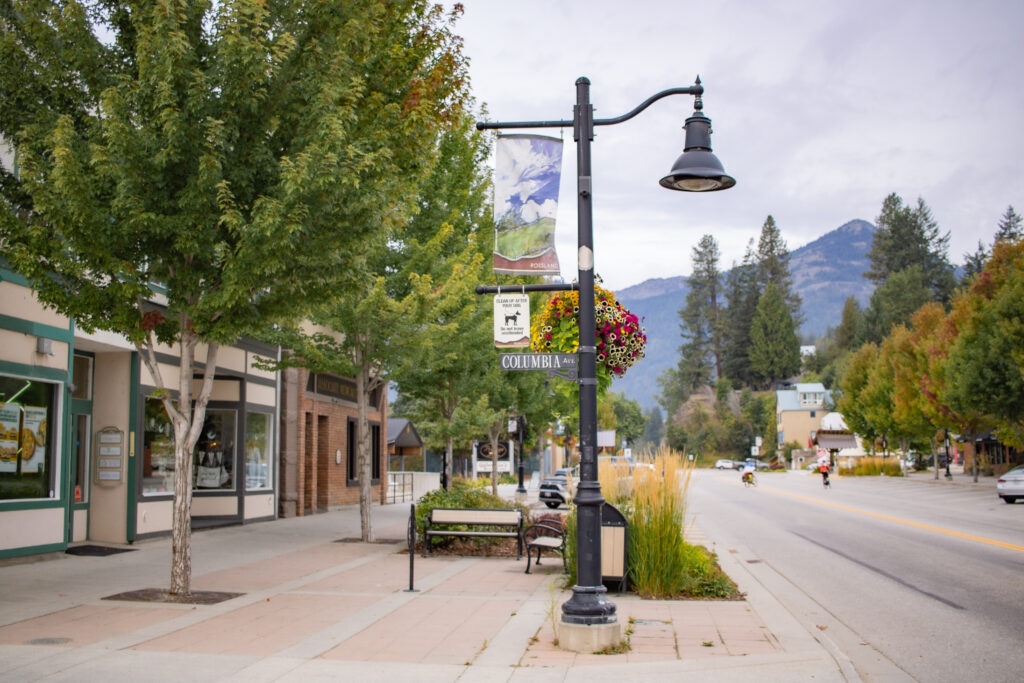 Charming view of downtown Rossland BC with heritage brick buildings, mountain backdrop, and local shops along Columbia Avenue.